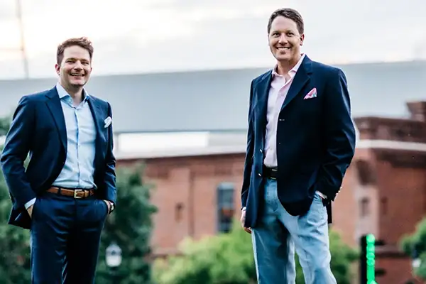 Dr. Cunningham and Dr. Gazdeck posing for the picture with their dental clinic in the background.