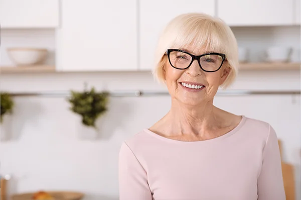 Joyful nice woman standing in the kitchen.