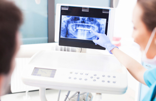 Dentist explaining digital x-ray impressions to patient