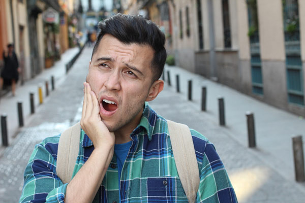 Man in pain holding his jaw.