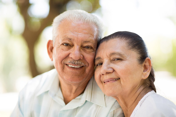 Smiling older couple leaning cheek to cheek