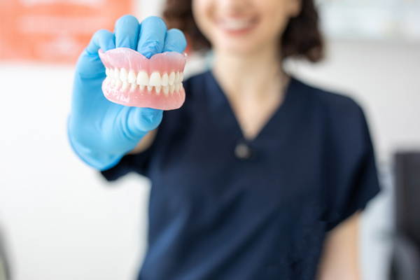 Woman holding a set of dentures